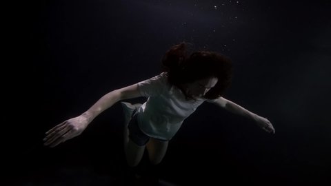 an adult woman with no signs of life as in space the body hovers in the weightlessness of water