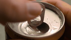 Opening refreshing can of beer soda, close up macro. Adult opens holds in his hand a cold aluminum can of carbonated drink with drops of water and opens the lid with his fingers. - Powered by Shutterstock - Get 15% off with code: PIKWIZARD15