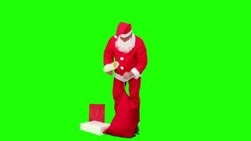 Santa Claus checking his list of gifts against a green screen