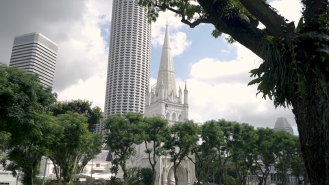 View Of St Andrews Cathedral In Singapore With Raffles City Tower In Background - tilt-up