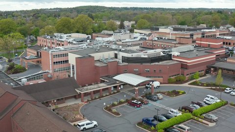 Wide angle aerial of hospital in USA. American healthcare system. Emergency exit and American flag. Insurance and ACA theme.