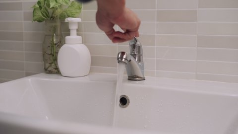 man use hand closes water tap. Turning off the water when not in use saves energy and reduces global warming. Concept save energy save the world.