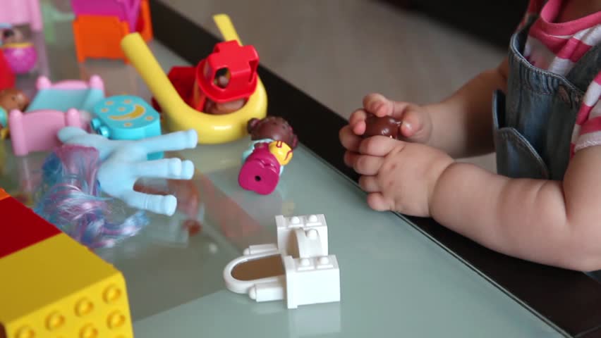 Small kid playing with constructor toy. Only hands in frame