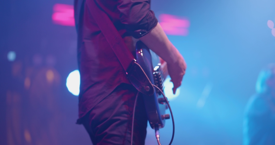 Man is playing guitar on stage. Young man playing on electric guitar. Artist Guitarist hand close-up. Slow motion Royalty-Free Stock Footage #1072650443