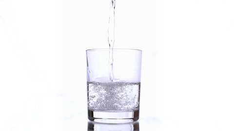 Water being poured into Glass against White Background. Isolated conceptual footage