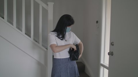 Casual women putting on mask and leaving house