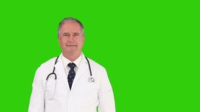 Chroma-key footage of a mature doctor with stethoscope looking at the sky