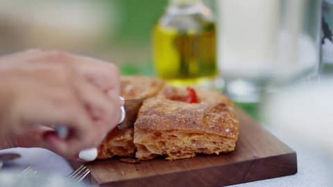Cutting focaccia bread with a knife