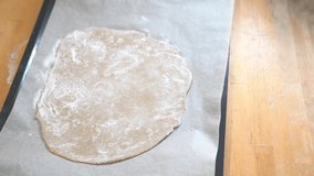 Girl cooks pizza, smears tomato paste on dough in the form of a circle. High quality 4k footage