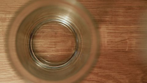 Top view of pouring a glass of mineral drinking water from a bottle