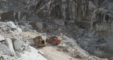 Apuan Alps, Tuscany, Italy.  2020. Marble quarry with excavator Marble quarry in the Apuan Alps in Tuscany. Large mechanical vehicles at work in a marble quarry in the Apuan Alps.