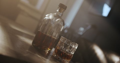 Close-up of a man's hands with a glass of whiskey. A man drinks alcohol alone, he thinks for a long time before drinking whiskey.
