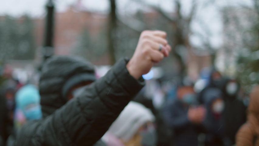 Revolutionary opposing activist with raised fists. Angry protester raises hands. Oppositional people peaceful striking activism. Rebel protester man on city picket. Aggressive riot person swings fists Royalty-Free Stock Footage #1072672787