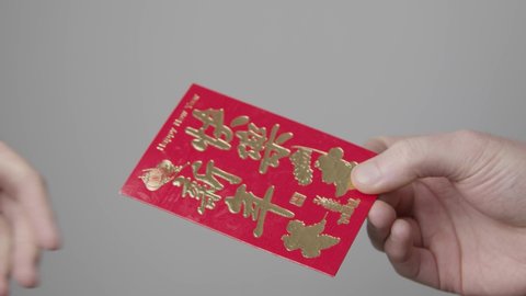Close Up Shot of One Hand Taking a Red Packet from Another On Chinese New Year