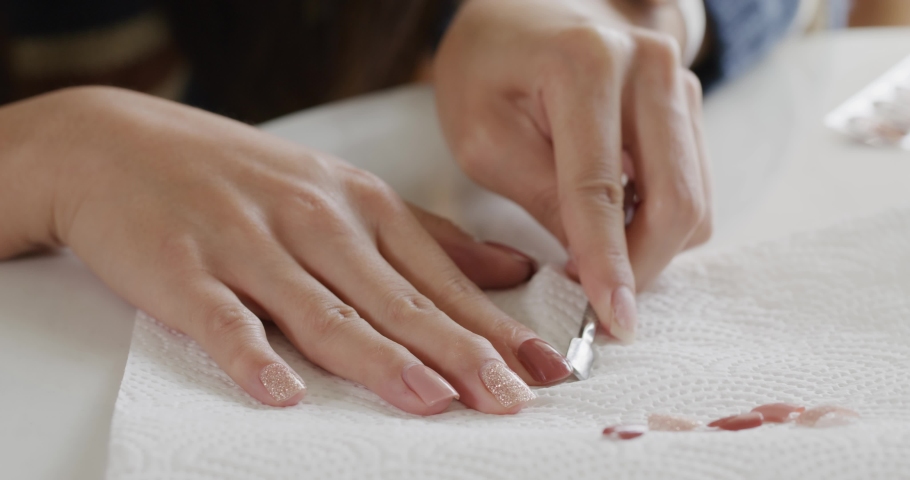 Woman take off her gel nail at home