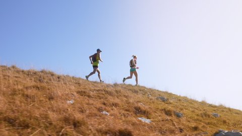 Two marathon runners running on a hill in slow motion
