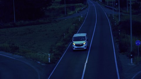 Aerial view of a white delivery van driving on the road in the evening