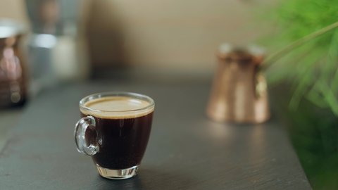 Coffee made in a Turk is poured into a glass glass. Strong aromatic coffee brewed in a cezve for breakfast, the idea of making coffee in a traditional oriental way