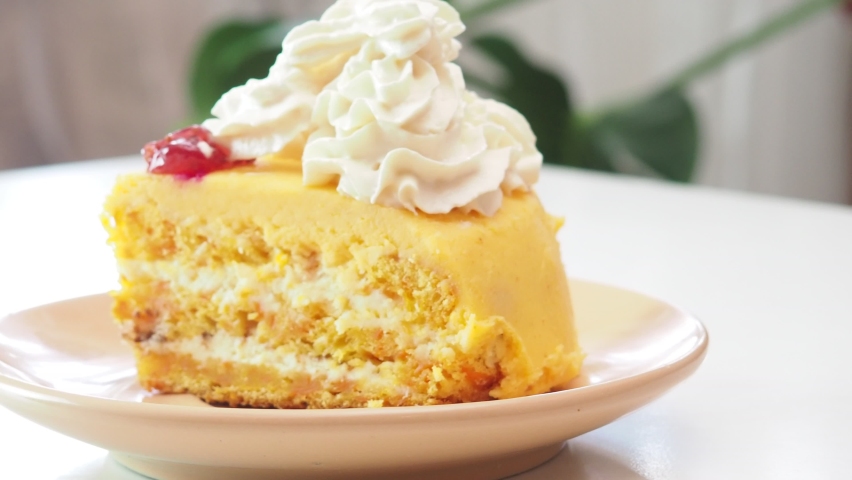 pumpkin or carrot pie or cake with cream on top. Pumpkin Pie with whipped cream, pecan nut and cinnamon on white background. Homemade autumn pastry for Thanksgiving - piece of pumpkin pie.
