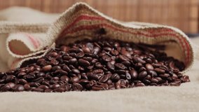 Close-up of dark black roasted coffee beans. An ingredient for making coffee. Environmental materials. Natural coffee. 4k video.