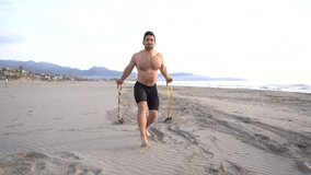 metabolic workout on the beach with muscular man performing chest and rubber variant with kettlebell at sunrise