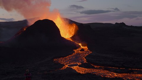 Aerial slow motion of exploding Geldingadalir Volcano with flowing lava after sunset in Iceland.