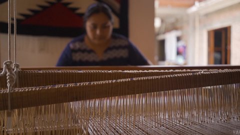Mexican artisan jobs. woman using a hand weaving loom to elaborate traditional fabric. 