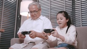 Happy family girl and grandfather having fun with playing game console for relaxing free time together at home