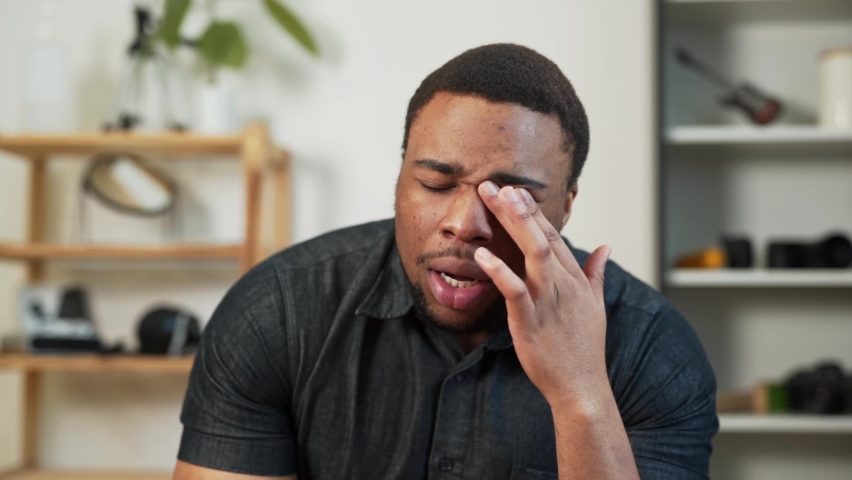 Close-up portrait of a black man whose eyes are sore and burning
