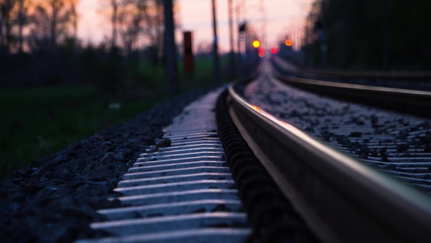 Dreamy low angle view of railroad tracks disappearing in the distance at sunset. Concept of travel and unknown destination. Dolly right. Royalty-Free Stock Footage #1072718279