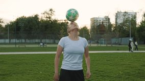 Woman football soccer player practicing tricks with ball on head, in the park at sunset. Urban city lifestyle outdoors concepte. - Powered by Shutterstock - Get 15% off with code: PIKWIZARD15