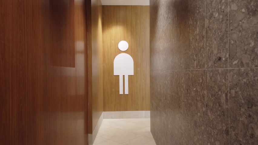 Toilet sign. A visitor to a modern shopping center approaches the toilet. Royalty-Free Stock Footage #1072723052