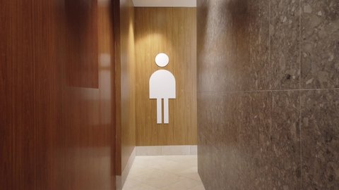 Toilet sign. A visitor to a modern shopping center approaches the toilet.
