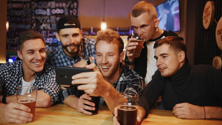 Group of soccer fans together indoors in the pub have fun at weekend time.