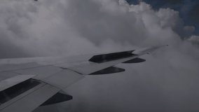 View from airplane at clouds. Handheld footage, through the plane's window.