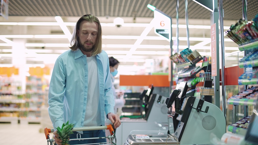 Man buys vegetables and fruits in a modern supermarket, contactless purchase of products in a store, the purchase process using a self-service checkout and NFC. Royalty-Free Stock Footage #1072733111