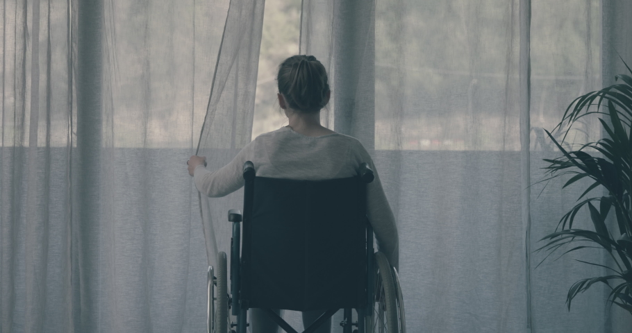 Disabled woman at home alone: she opens the curtain and looks outside | Shutterstock HD Video #1072734815