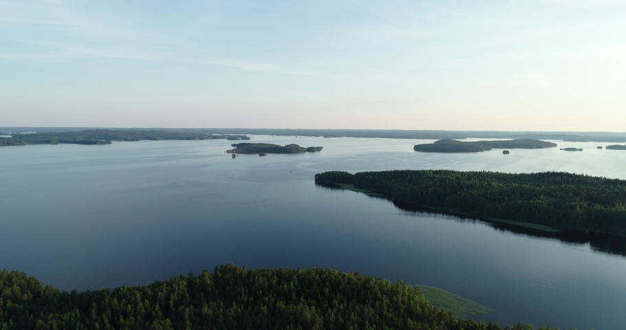 A calm evening lake with islands in Finland.  Popular tourist attraction. Exploration travel world. Crystal clear water and Perfect blue sky.