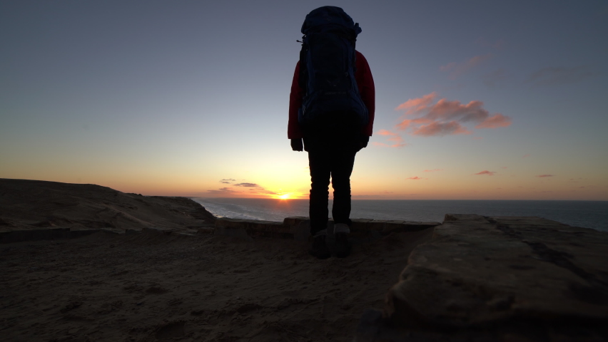 Wide Static Shot Of Hiker With Backpack Watching Sunset From Beach, Rubjerg , Hjorring, Denmark