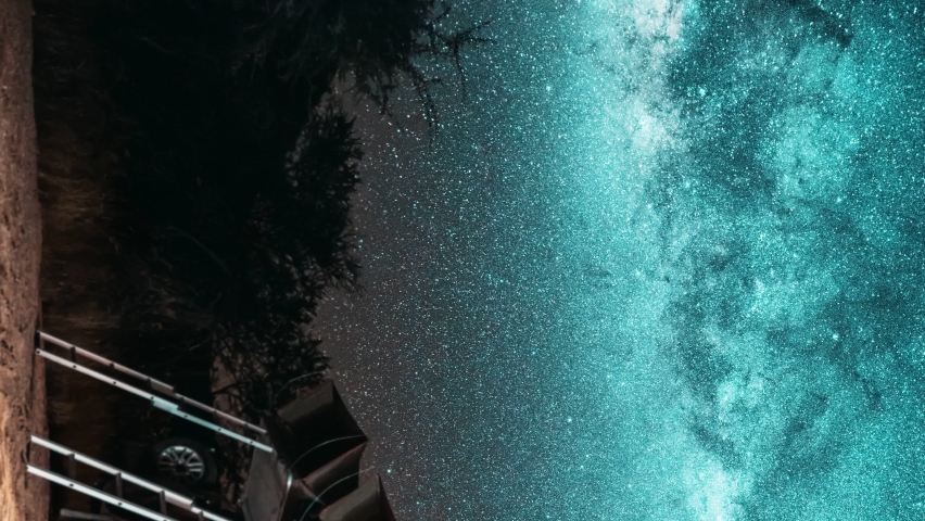 Vertical video. Astronomy Namibia starry landscape, travel in galaxy. Night timelapse of a safari vehicle in an adventurous wild camping location with rooftop tent against the Milky Way and starry sky