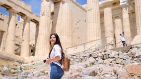 A tourist woman on summer vacations walks up to the Parthenon Temple at the Acropolis of Athens, Greece - Powered by Shutterstock - Get 15% off with code: PIKWIZARD15