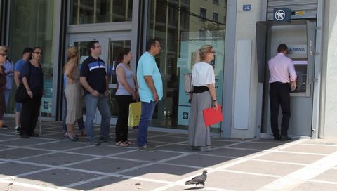 ATHENS, GREECE - JULY 7TH, 2015: Citizens line up to use an ATM outside the Alpha Bank, on July 7th, 2015, in Athens, Greece. A withdraw limit of 60 euros per day allowed by the capital controls.