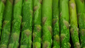cooking green asparagus on grill pan, close up. Sliding shot. 4K UHD video
