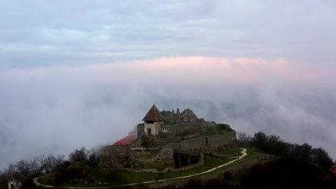 Visegrad Hungary. Visegrad citadel castle ruins in Danube bend Hungary. Fantastic aerial landscape in bad weather. Foggy, cloudly sunrise. Scary cinematic view with haze. 