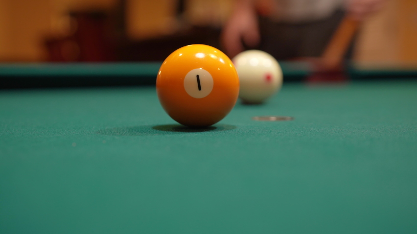 Man Playing 8 Ball Pool Gets Down and Shoots Solid Yellow One Ball into Pocket Past Camera using Draw or Backspin and Wooden Cue Stick on a Brunswick Table with Green Felt, Playing Billiard Bar Games | Shutterstock HD Video #1072780898