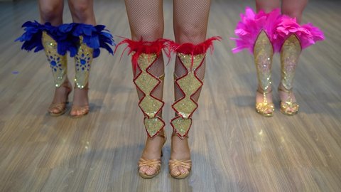 Dancing samba legs close-up, three girls practice dancing samba at the studio wearing show costumes