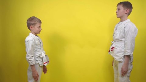 boys in kimono performs a greeting before starting a workout on a yellow background close-up, Ritsu Rei respect in sports sports, karate, aikido, judo, wushu, taekwondo Sports lifestyle. Martial Arts