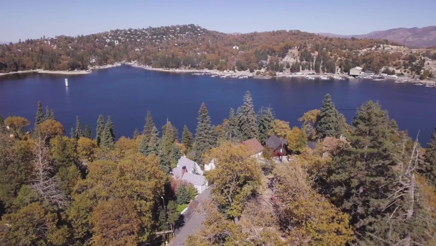 Aerial revolve left over houses on hill and lake
