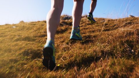 Tracking shot of marathons' legs jogging through the wasteland in slow motion