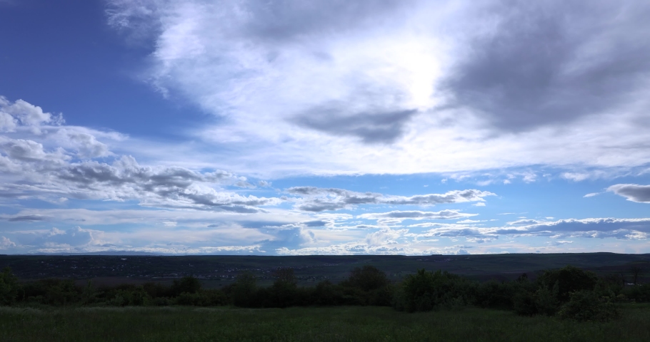 Beautiful clouds over green landscape - time lapse